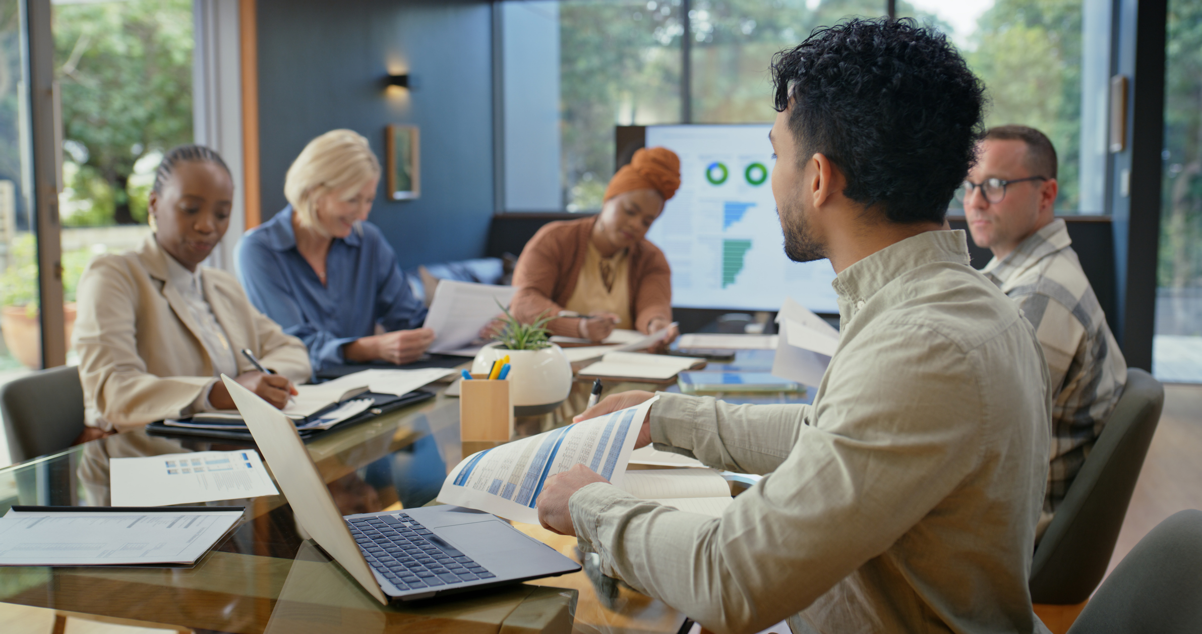 People, meeting and laptop with documents in office for research, finance report and budget review. Team, reading and tech with financial paperwork, company audit and information for profit increase