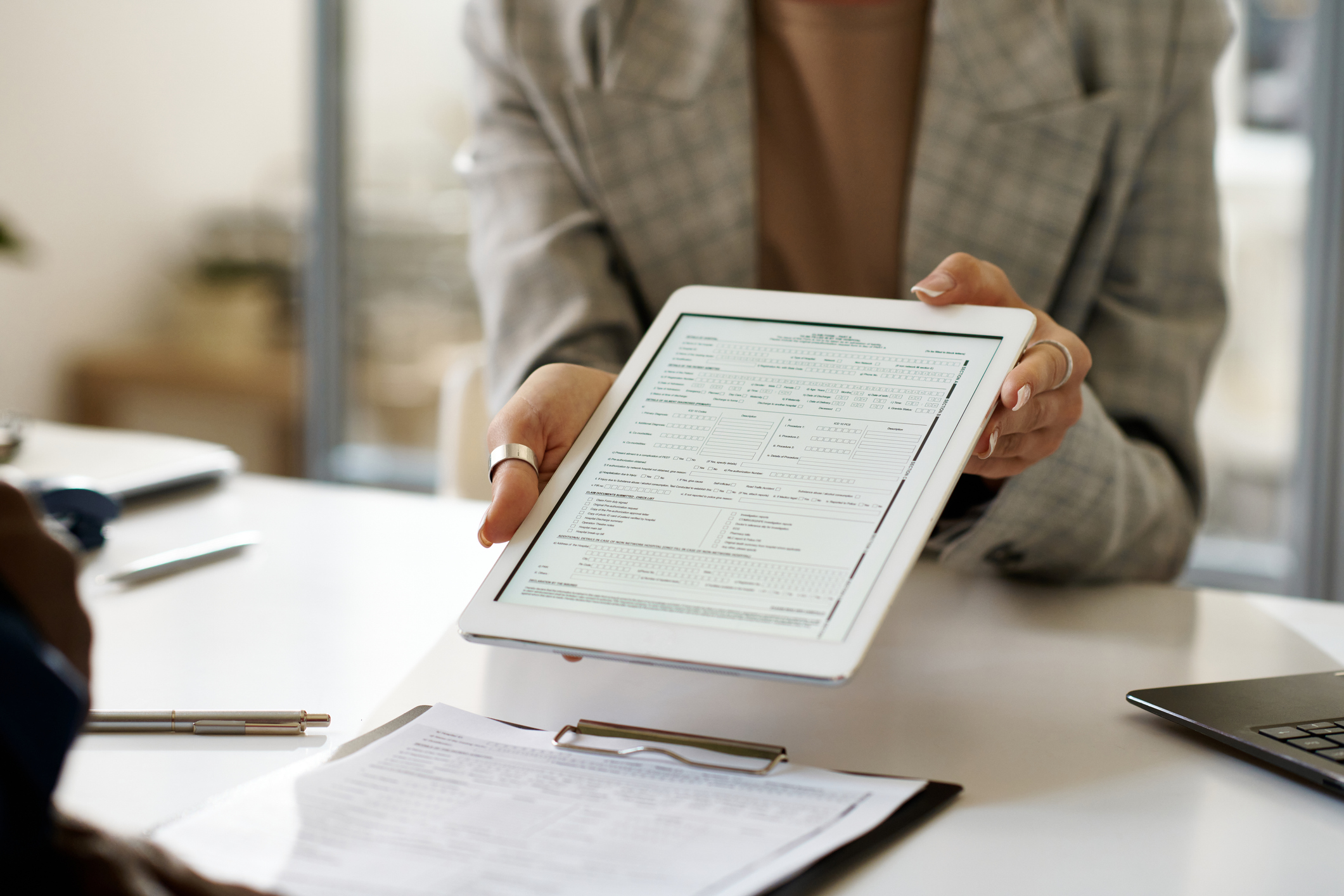 Businesswoman showing contract on tablet pc to client